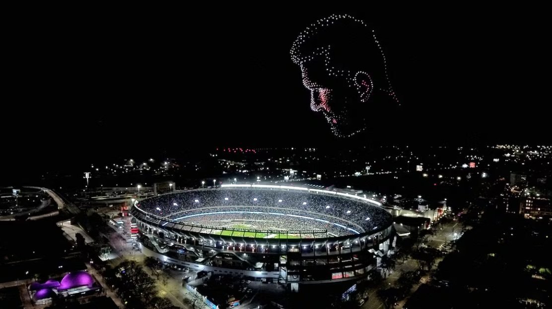Cientos de drones dibujan en el cielo nocturno el rostro de Lionel Messi, sobre el estadio Monumental iluminado y colmado de público.